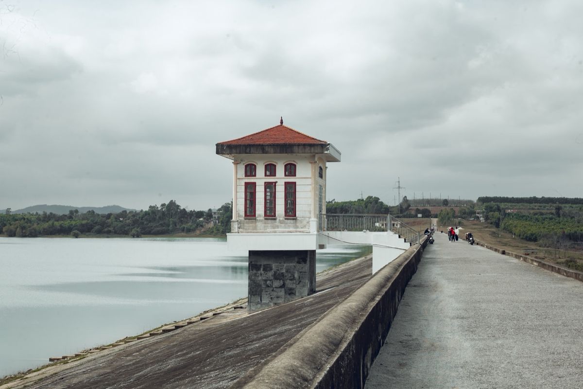 Dam with a tower above a calm reservoir