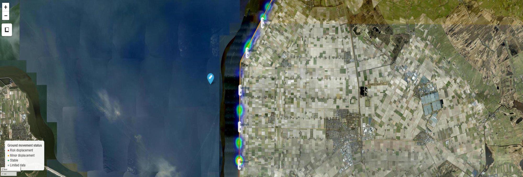 Satellite view of a coastline with a dyke separating the sea from farmland