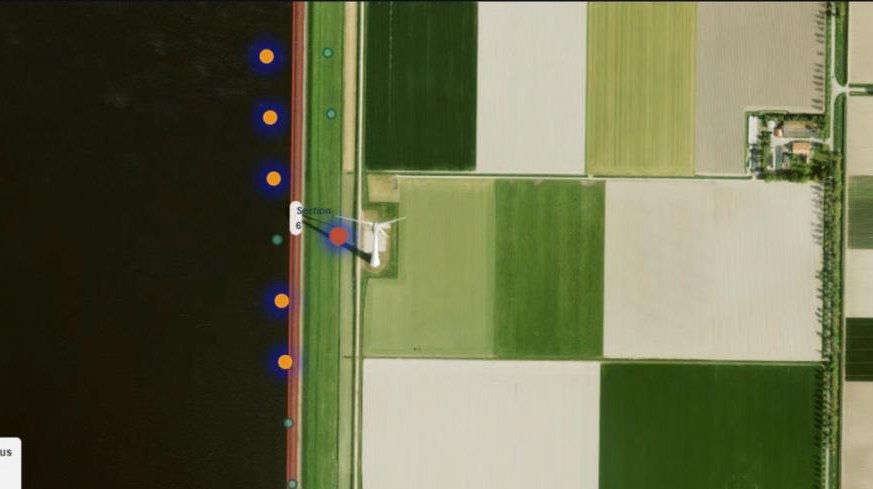 Aerial image of a dyke with coloured points marking the ground movement status of each measurement point