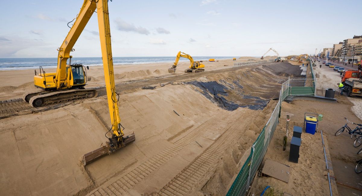 Excavators building a sea dyke on a beach